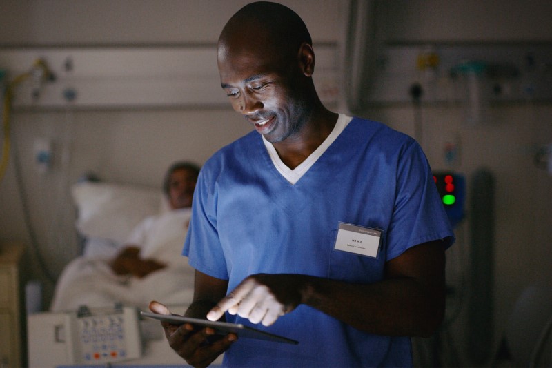 photo of clinician using handheld device in a ward setting